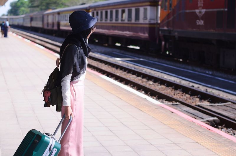Rear view of woman walking on railroad station