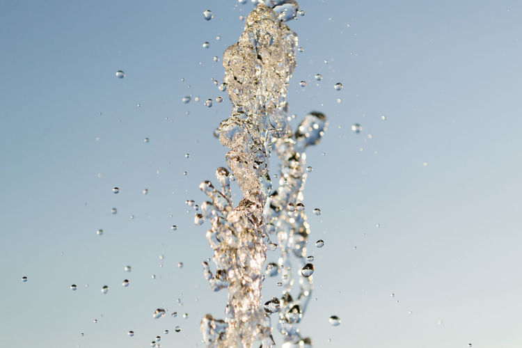CLOSE-UP OF SPLASHING WATER AGAINST SKY