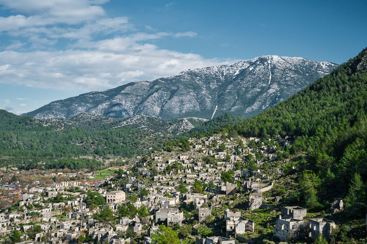 View of an abandoned city near kayakoy village and snow-capped mountains.  ghost town karmilisos 