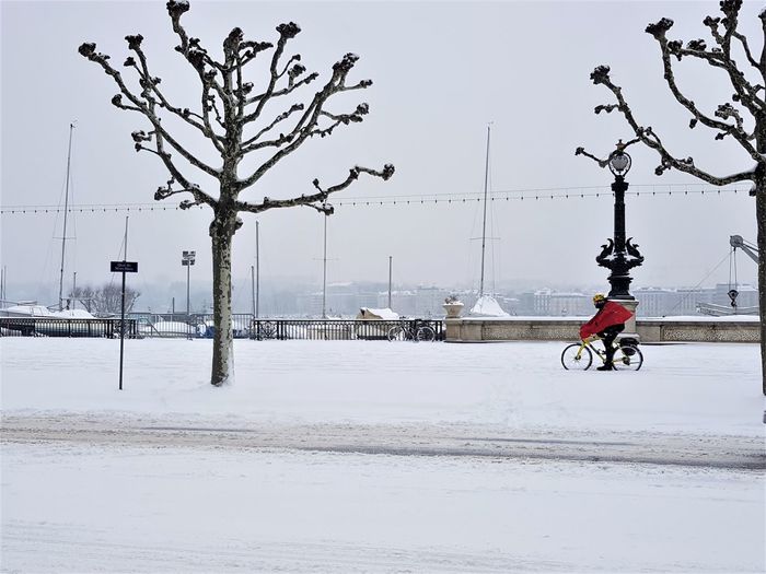 Man riding bicycle on street in winter