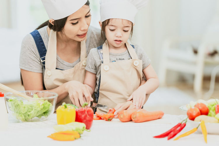 Midsection of woman having food in kitchen