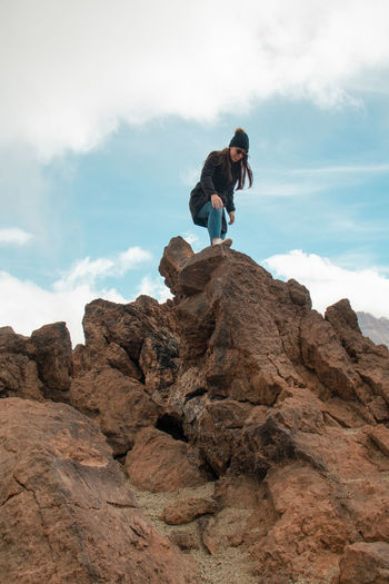 Low angle view of man on rock against sky