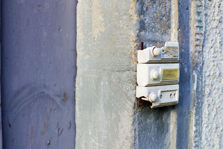 Close-up of abandoned doorbell on wall