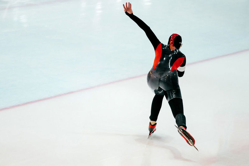 Man in sports uniform ice skating at rink