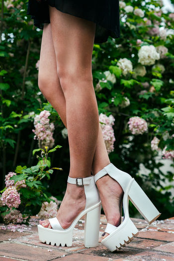 Low section of woman wearing high heels standing outdoors