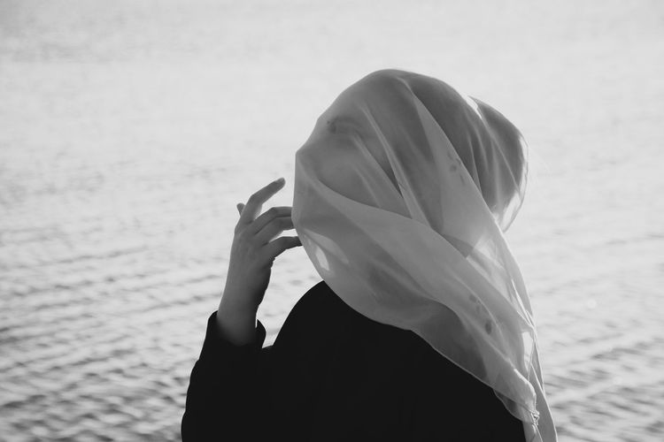 Close up of woman with covered face by lake