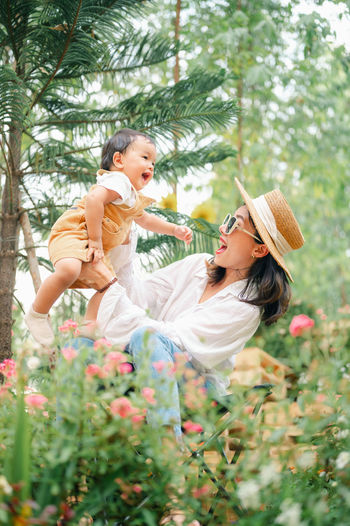 Rear view of mother and daughter on flowering plants
