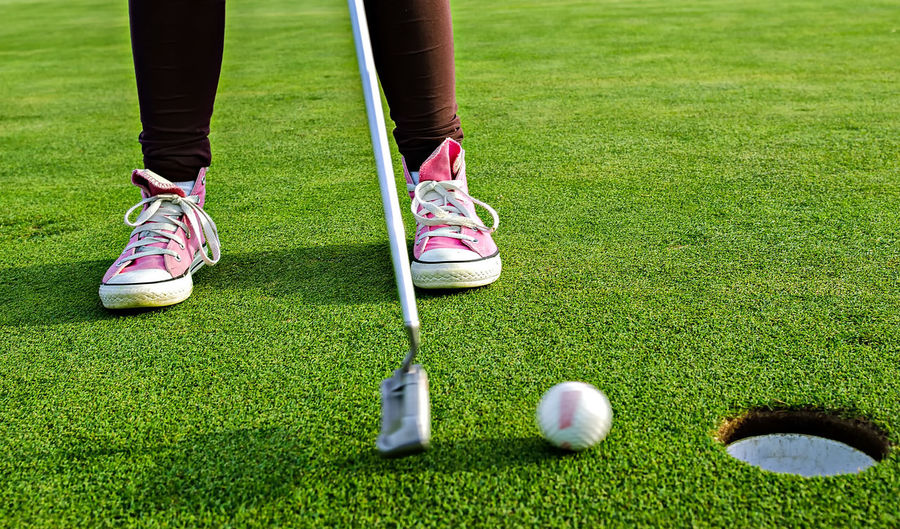 Low section of woman playing golf on course