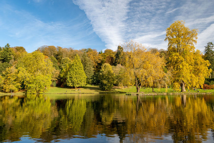 View of the autumn colours around the lake at stourhead gardens in wiltshire.