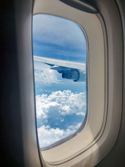 View of cloudy sky seen through an airplane window