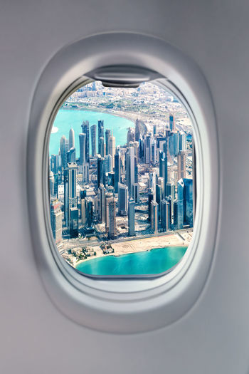 View from airplane window at doha skyscrapers. planes and cities concept.