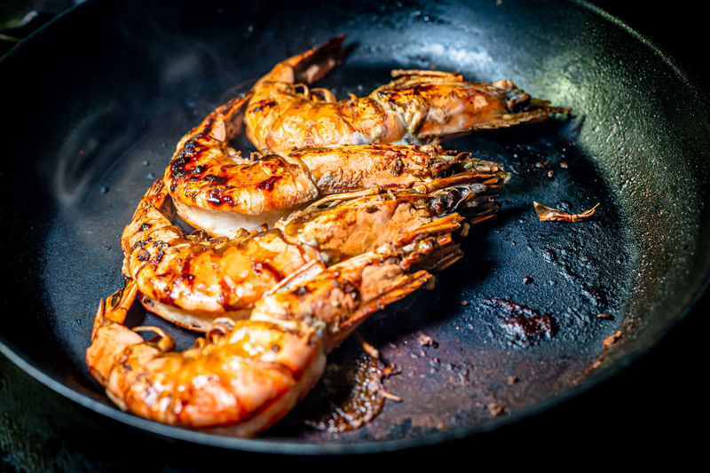 Grilled prawn in a frying pan on a dark background. seafood appetizer. preparation of food.