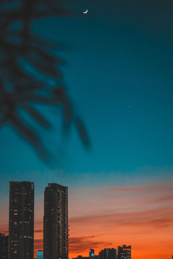 Silhouette buildings against sky at night