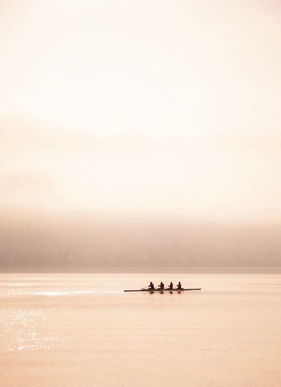 People on boat in sea against sky