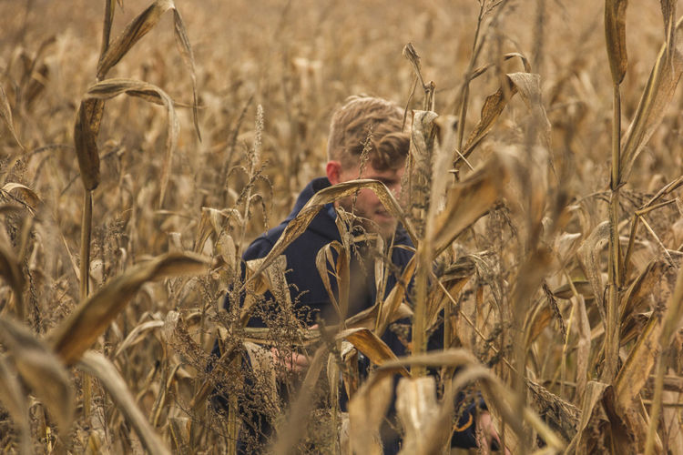 Man walking amidst crops growing on field