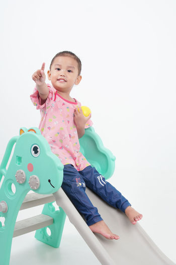 Portrait of cute girl with toy against white background