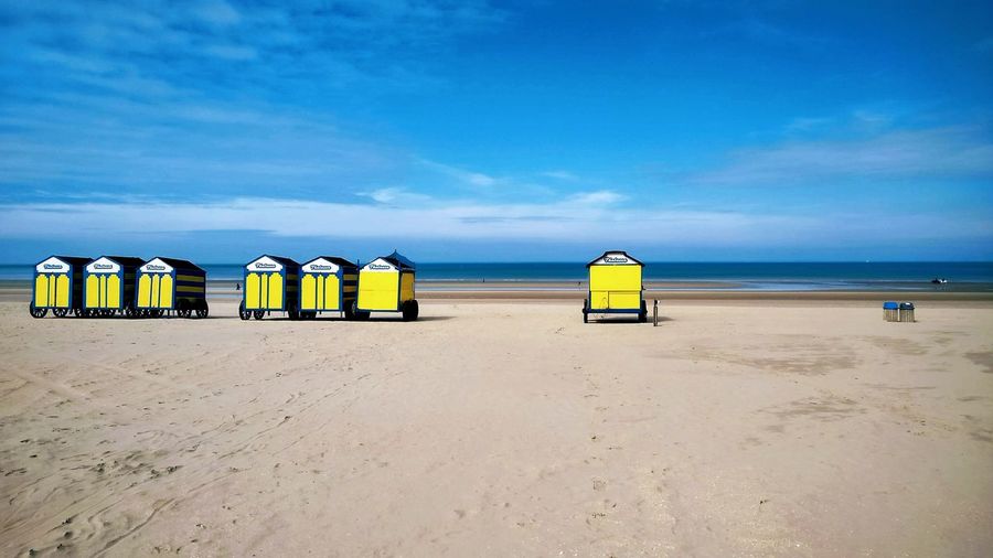 Trolleys at beach against blue sky
