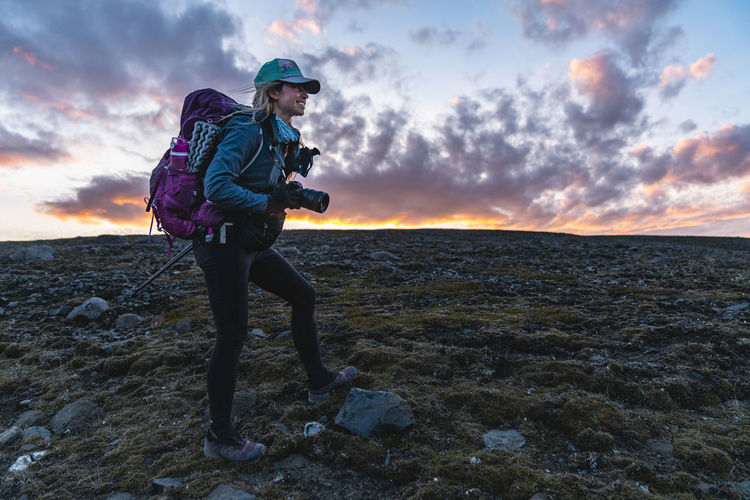 Backpacking photographer takes photos at sunset in remote highlands