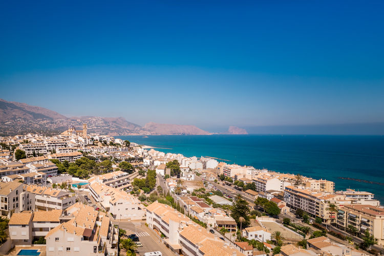 High angle view of townscape by sea against blue sky. altea, comunidad valenciana, spain