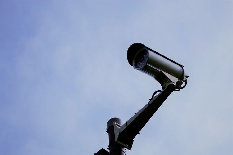 Security camera against blue sky