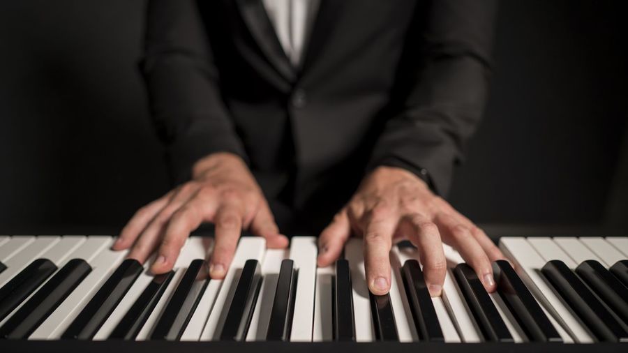 Midsection of businessman playing piano