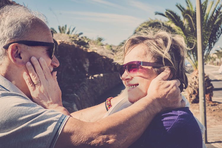Senior couple wearing sunglasses against sky