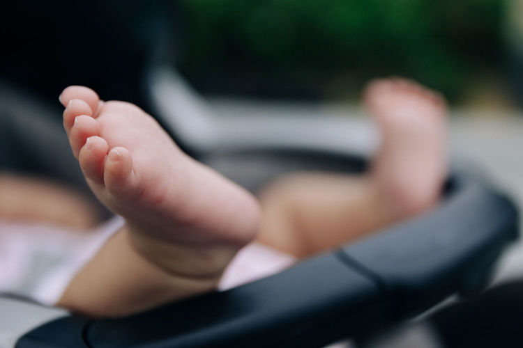 Low section of toddler resting in baby stroller