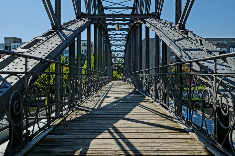 Metallic footbridge against sky