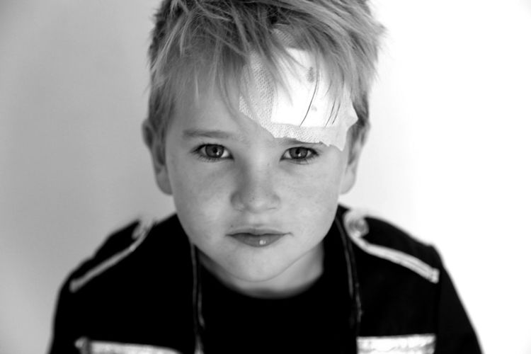 Close-up portrait of boy with bandage on forehead