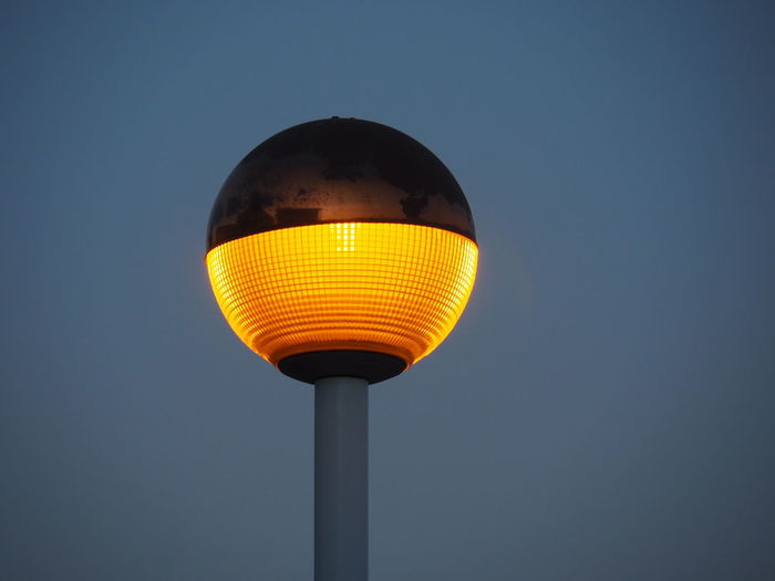 Low angle view of illuminated street light against sky