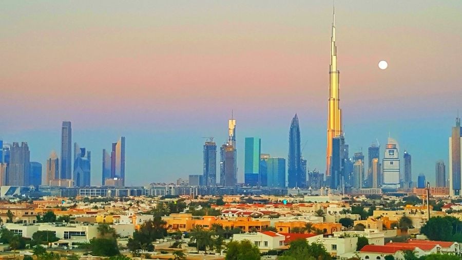Burj khalifa against sky during sunset in city