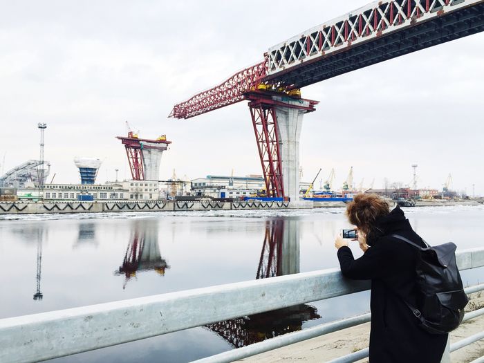 Woman standing by bridge against sky