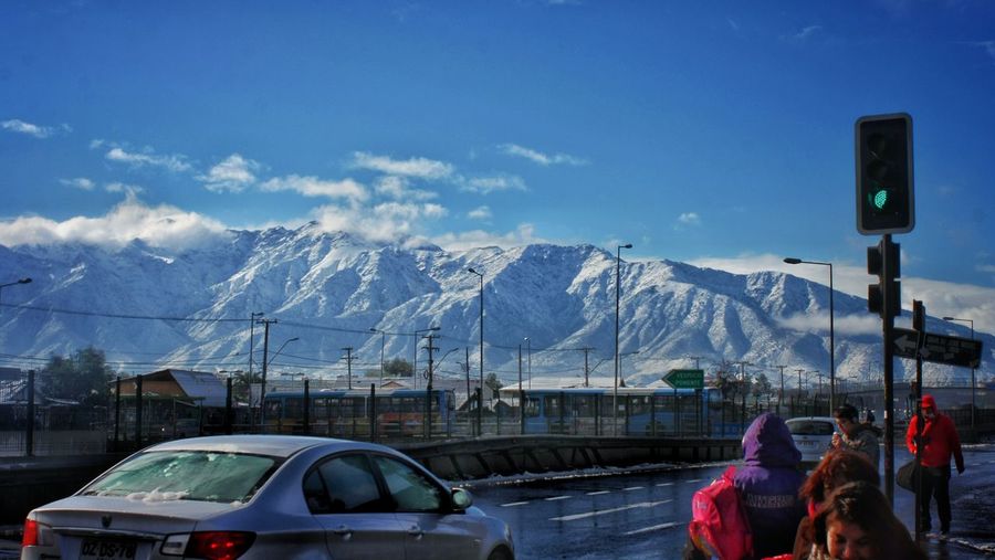 Cars on snowcapped mountains against blue sky