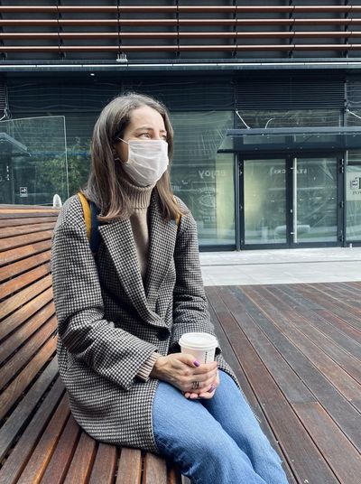 Full length of young woman drinking coffee