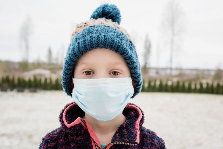 Young boy with face mask on protecting himself from flu and virus