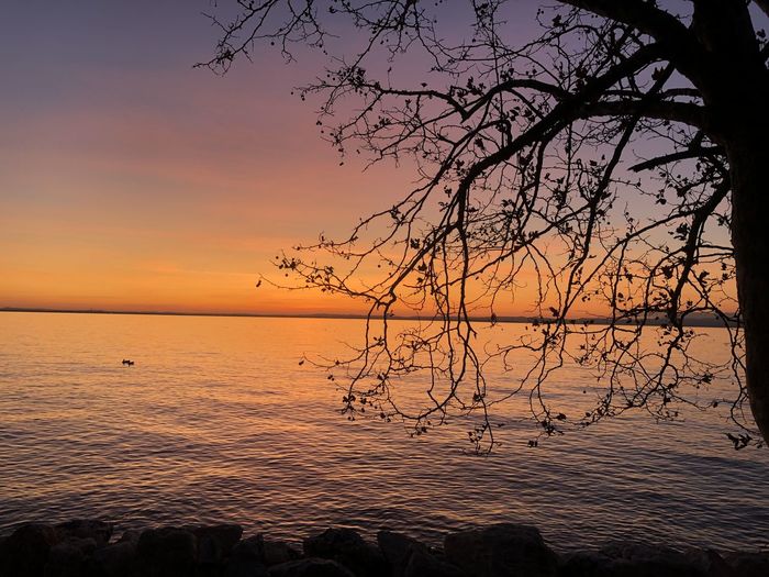 Scenic view of sea against romantic sky at sunset