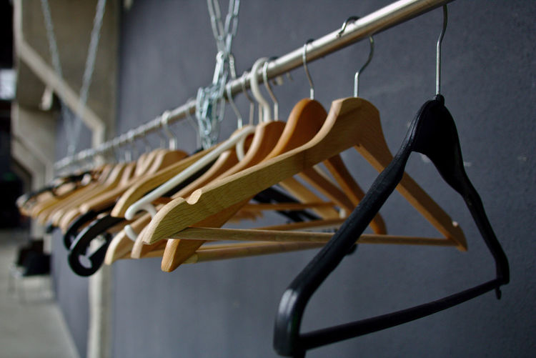 Close-up of clothes hanging on rack against wall