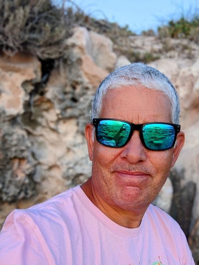 Portrait of man wearing sunglasses against rock formation