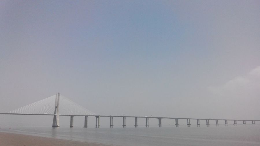 Vasco da gama bridge over tagus river against sky