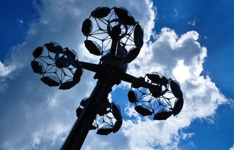 Low angle view of silhouette plants against clouds