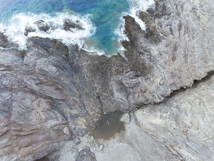 HIGH ANGLE VIEW OF ROCK FORMATION ON SEA