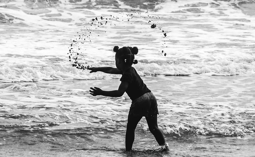 Full length of woman standing at beach against sky