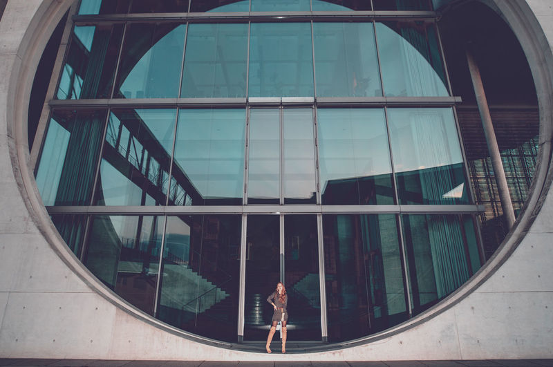 Young woman standing on circular window