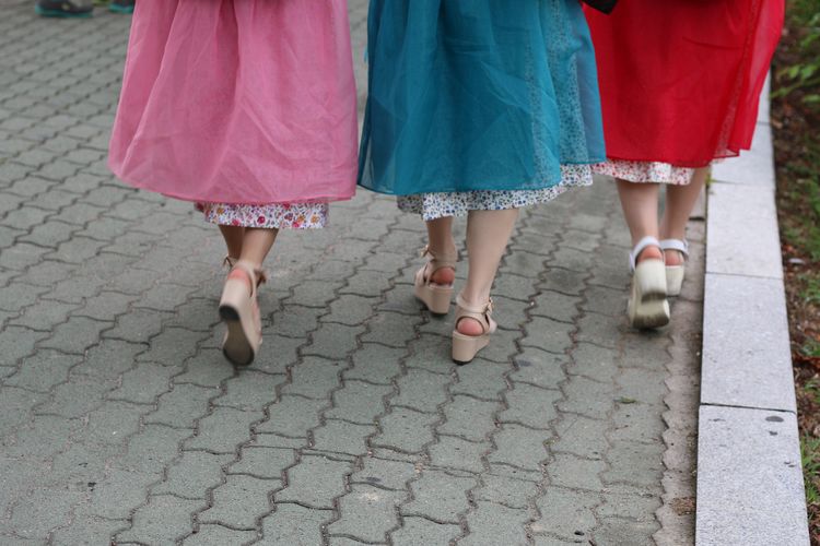Rear view of female friends walking on footpath