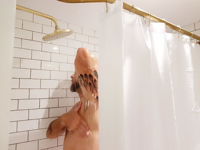 Man taking shower in bathroom