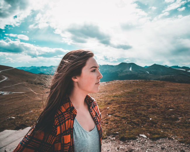 Beautiful young woman in mountains against sky
