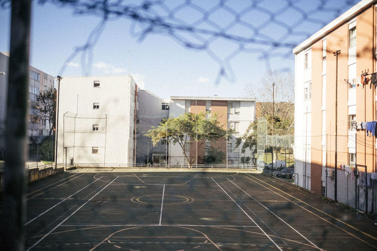 View of basketball hoop by buildings against sky