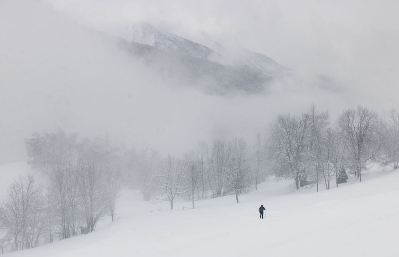 Man walking on snow covered landscape