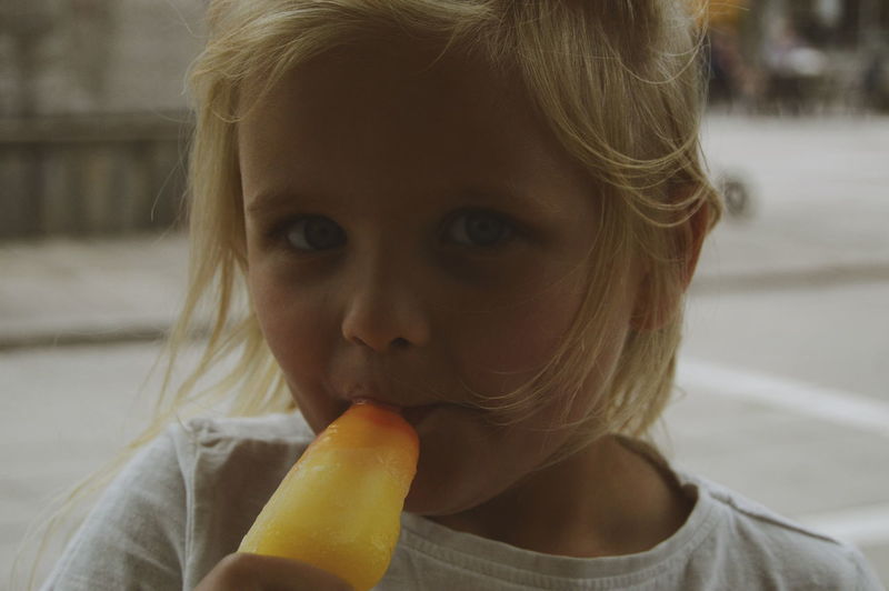 Close-up portrait of girl eating flavored ice