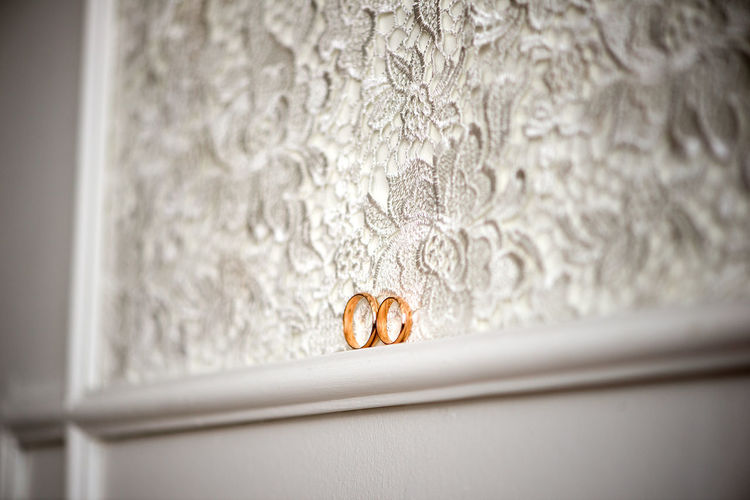 Wedding rings on white lace, marriage accessory, engagement background